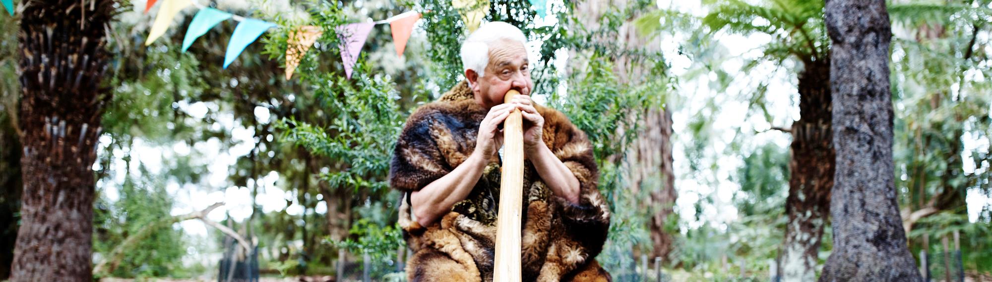 Murrundindi playing the Didgeridoo in the garden at Healesville Sanctuary.