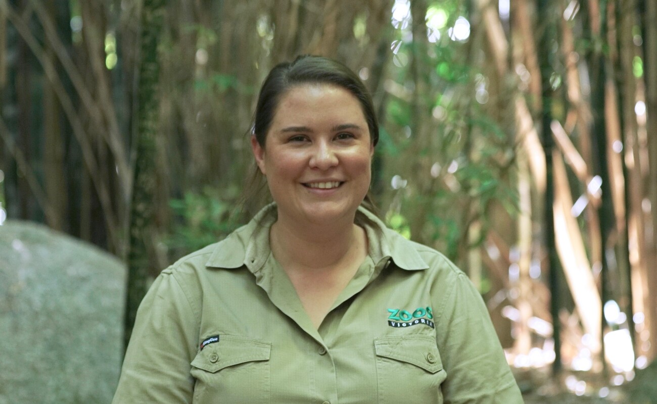 A female zoo keeper smiling at the camera