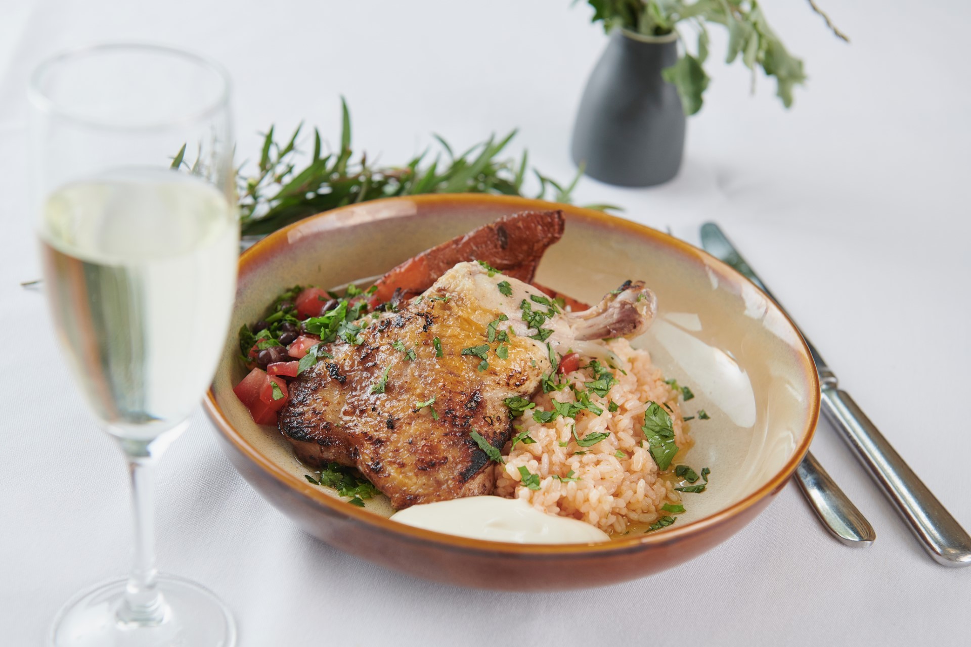 A marinated chicken dish with a glass of wine